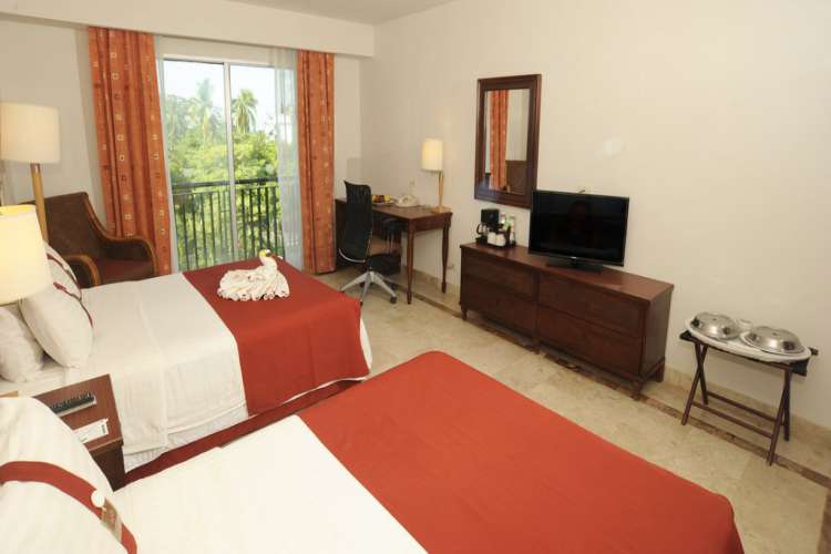 Hotel Gamma Inn Ixtapa Cuartos equipados con dos camas matrimoniales, aire acondicionado, clóset, kit de planchado, escritorio, internet inalámbrico, teléfono, TV por cable, detector de humo, caja de seguridad y cerraduras electrónicas, ideales para sus vacaciones en Ixtapa Zihuatanejo